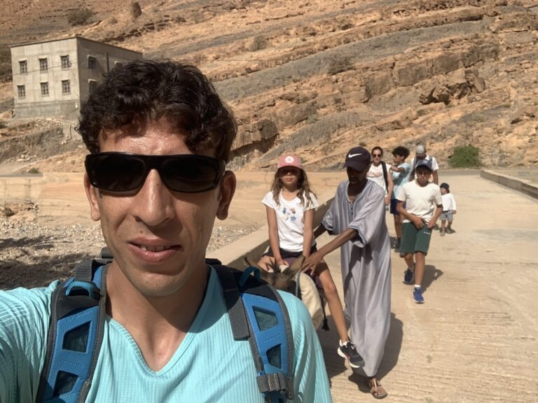 Guide leading a group of children hikers through Ait Mansour Gorge in Morocco